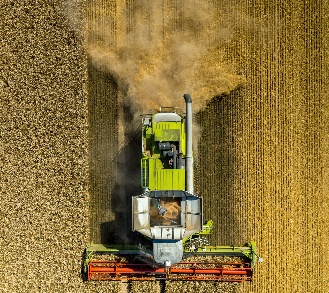 a tractor is driving through a field of crops