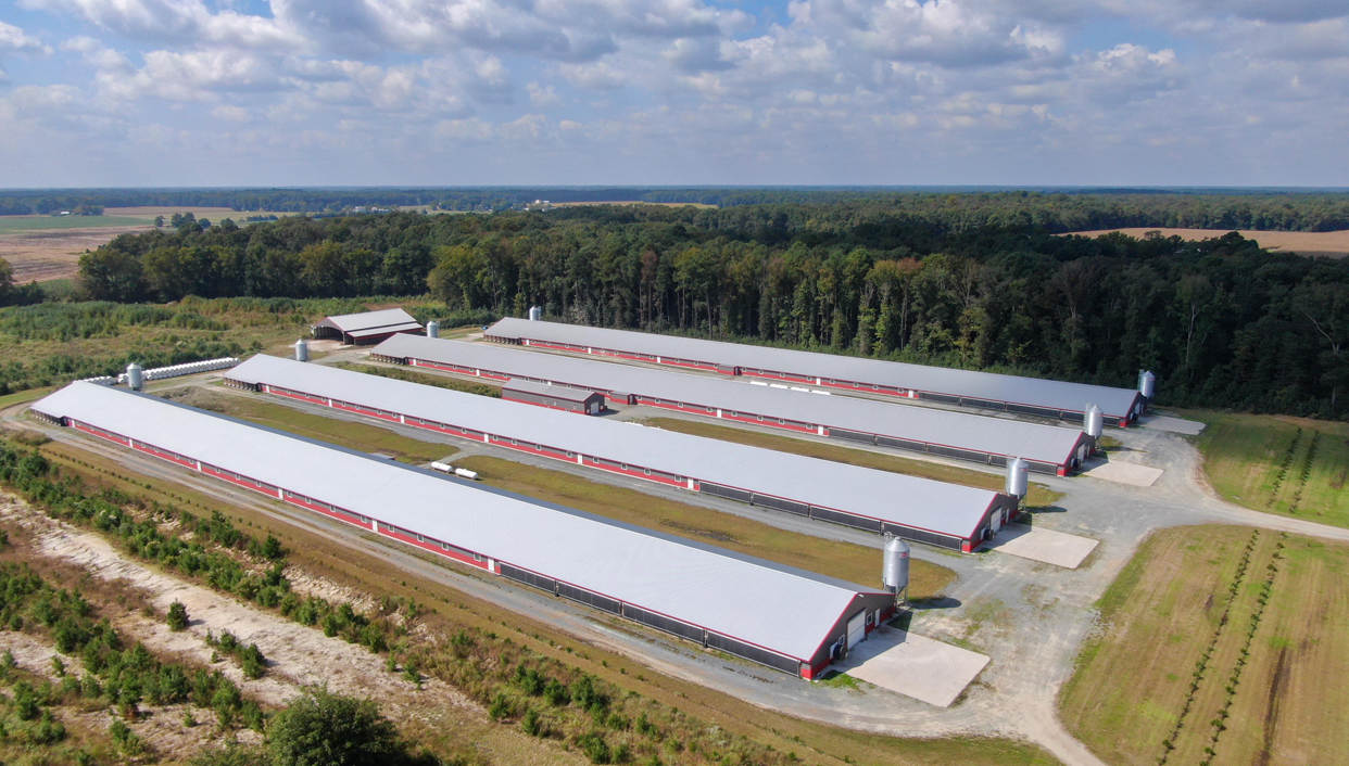 an aerial view of a factory building in the middle of a field
