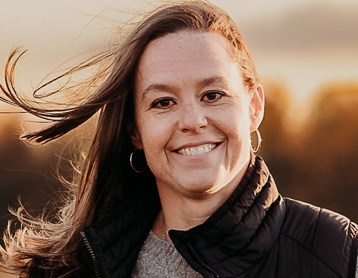 a woman with long hair smiling at the camera