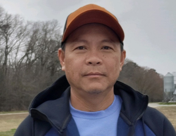 a man in a blue shirt and a brown hat