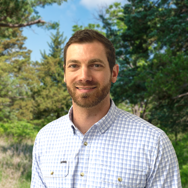 a man standing in front of a forest