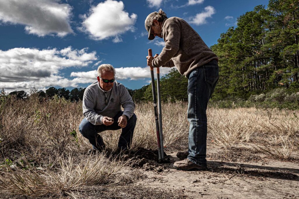 a couple of men standing next to each other in a field