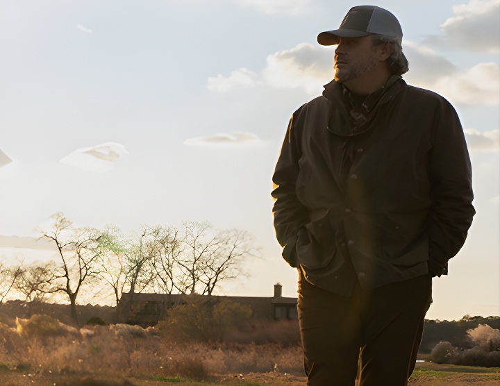 a man standing in a field with a frisbee