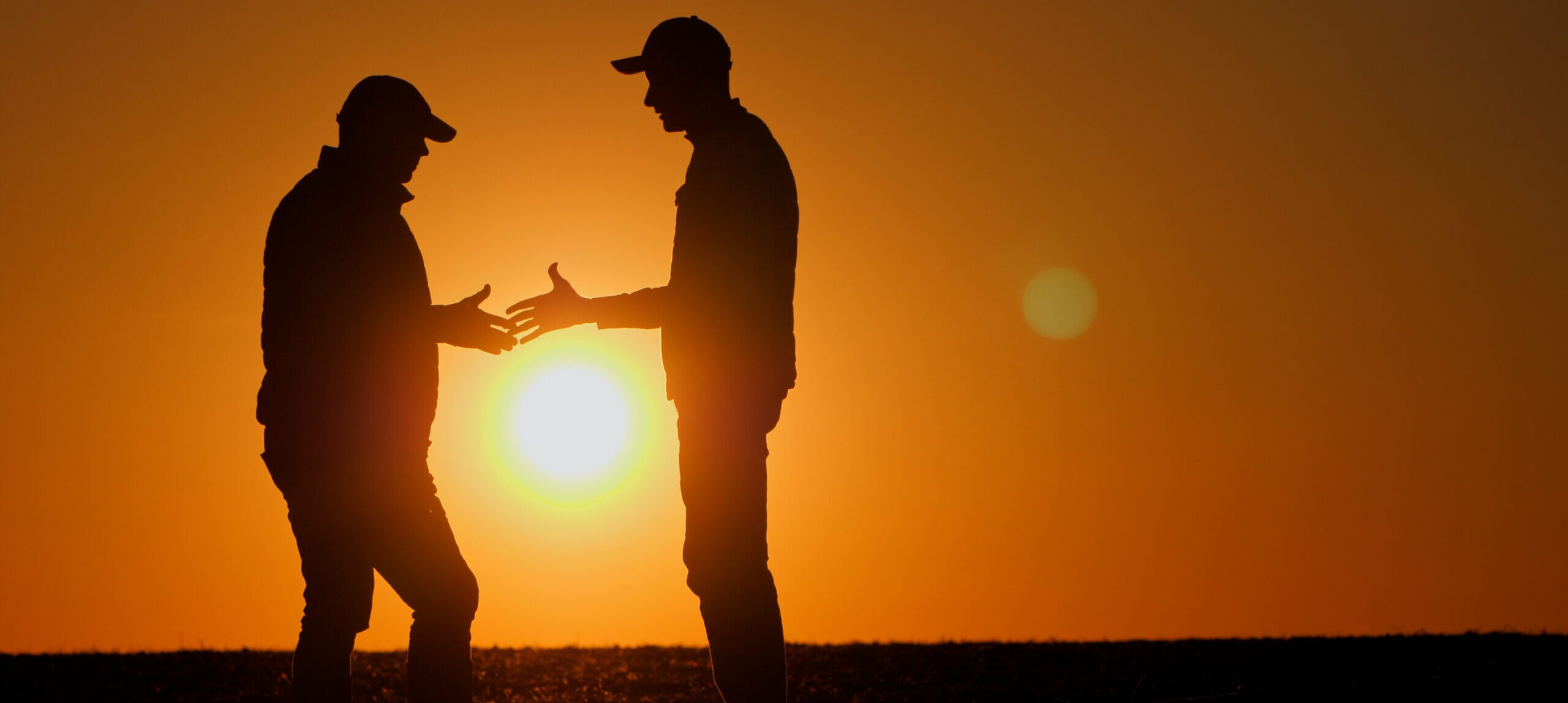 a couple of men standing next to each other in a field