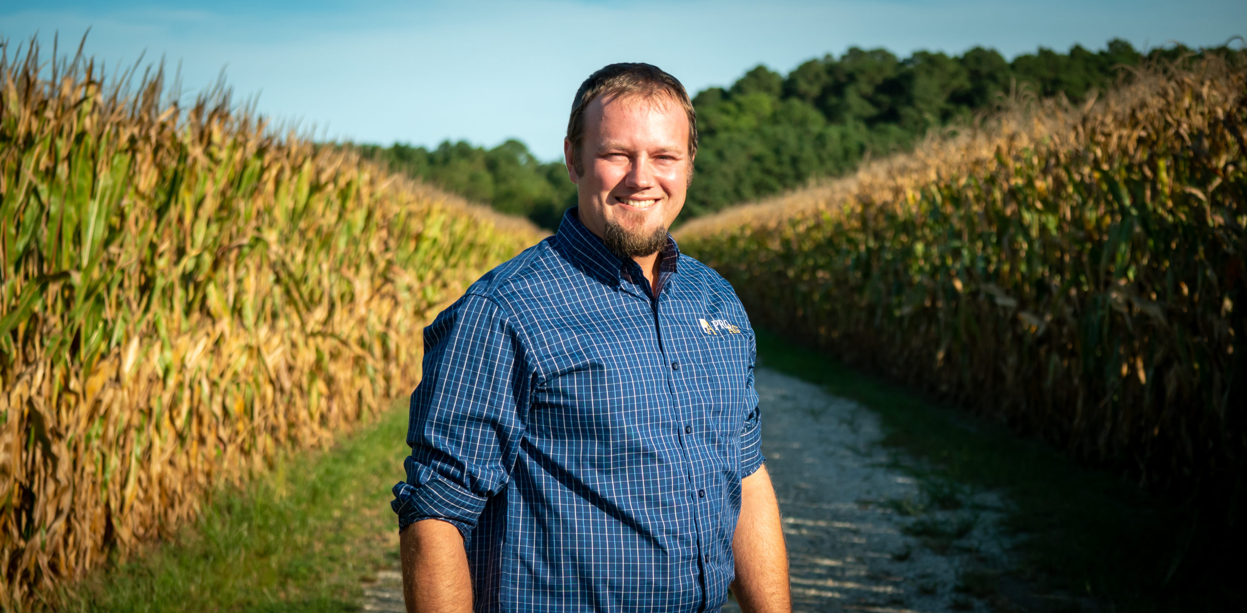a man standing in front of a corn field