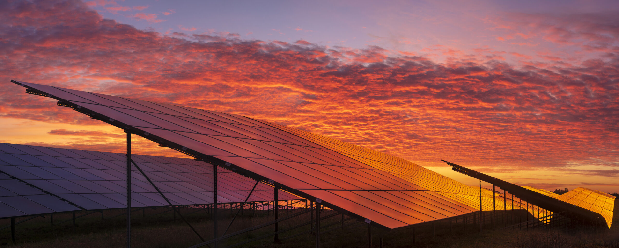the sun is setting behind a solar panel