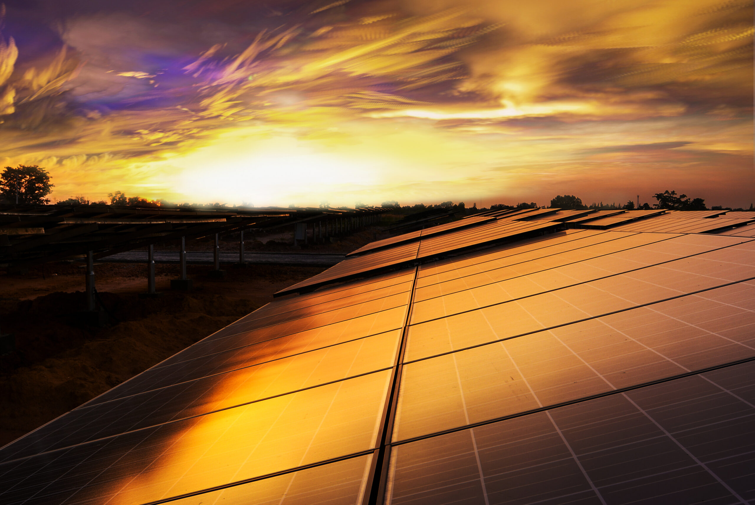 a solar panel with the sun setting in the background