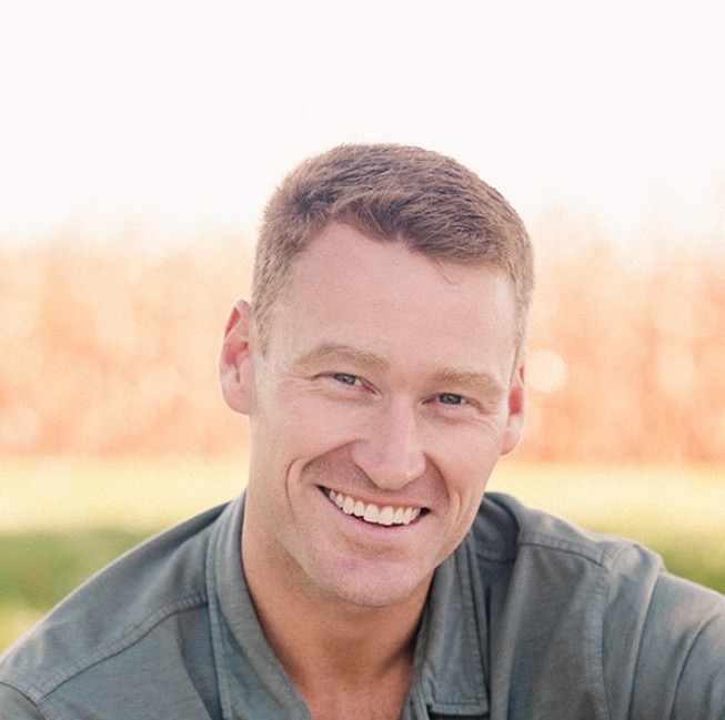 a smiling man in a green polo shirt