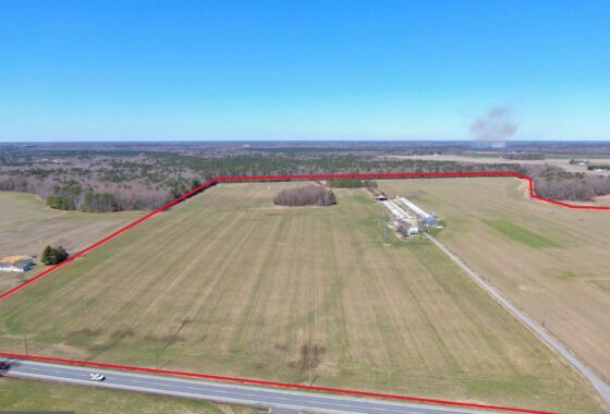 an aerial view of a large field with a road in the foreground