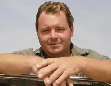 a man leaning on the hood of a car